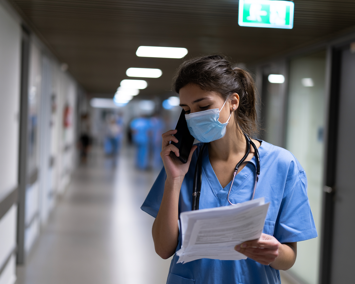 Nurse on phone in hospital corridor — ambient voice capture